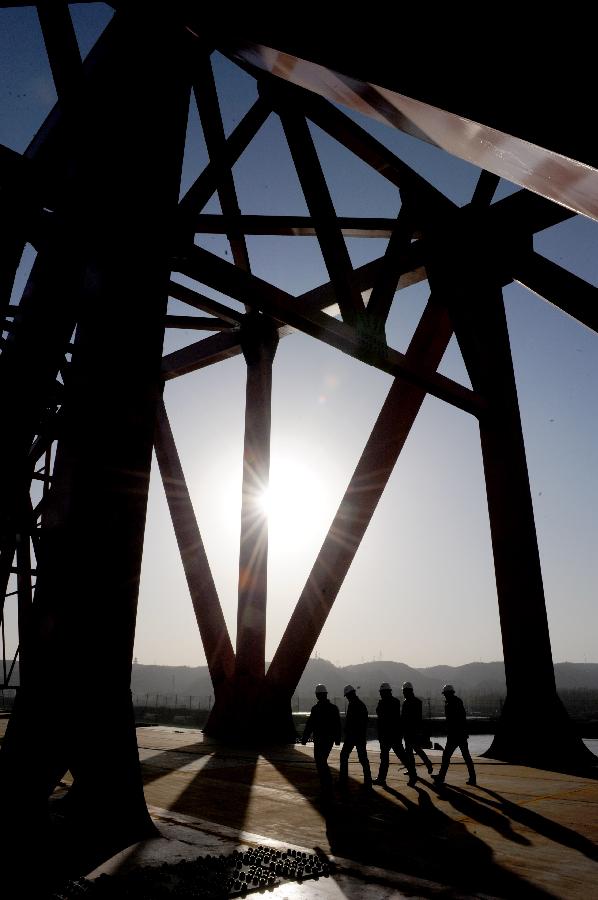 Several workers walk at the construction site of the Beijing-Guangzhou Railway bridge across the Yellow River in Zhengzhou, capital of central China's Henan Province, Nov. 26, 2012. The bridge, which is projected to be completed by the end of 2013, is the 6th Yellow River bridge planned to be built in Zhengzhou. (Xinhua/Zhu Xiang) 