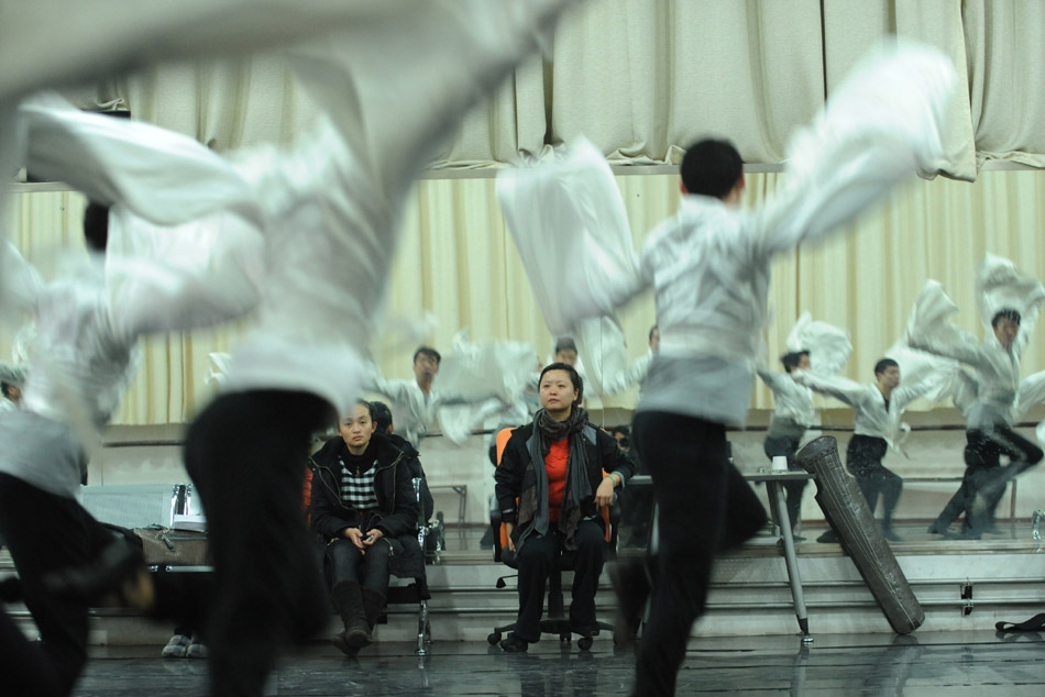 Director and choreographer Tong Ruirui (C) instructs performers during the rehearsal of the dance drama Goddess And The Dreamer in Zhengzhou, capital of central China's Henan Province, March 22, 2012. (Xinhua/Zhao Peng)