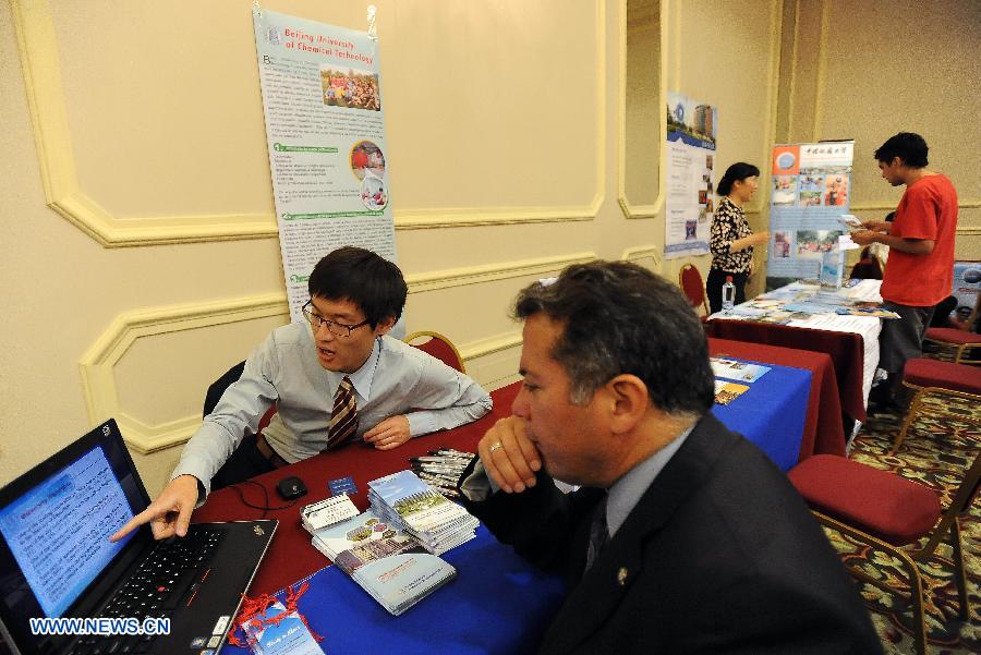 Exhibitors attend the "Chinese Universities Expo", held by the Chinese Embassy and the China Scholarship Council joint with the Chile's National Commission for Scientific and Technological Research (CONICYT), in Santiago, capital of Chile, on Nov. 26, 2012. The expo is held with the participation of 47 Chinese universities that will show their academic offerings and seek promote the interests of Chileans to study in China. (Xinhua/Jorge Villegas) 