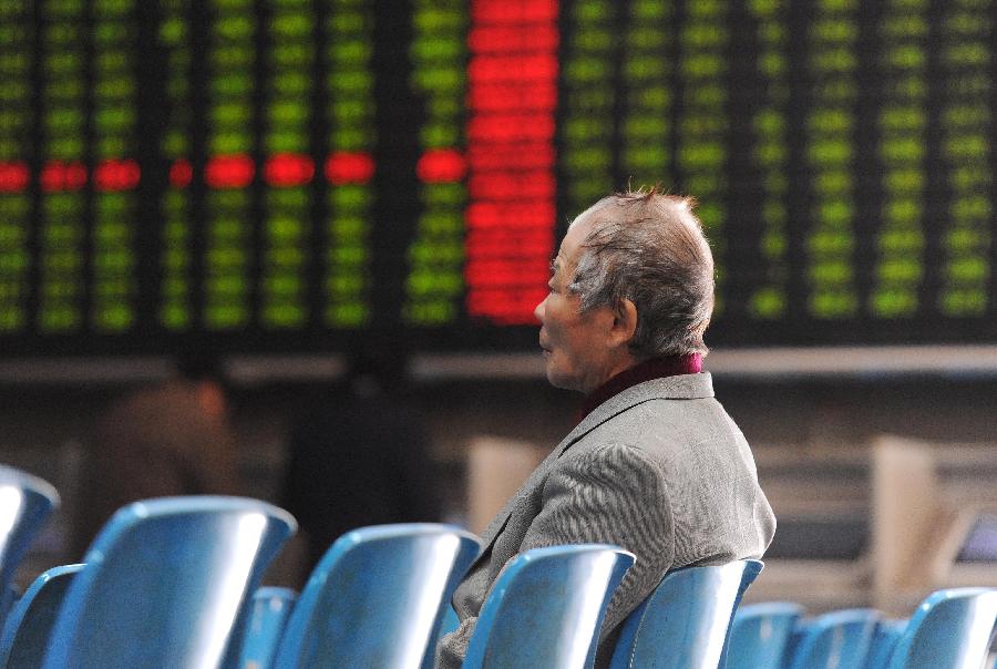 An investor looks at an electronic board showing stock information at a stock trading hall in Shanghai, east China, Nov. 27, 2012. Chinese stocks continued to fall Tuesday, with the benchmark Shanghai Composite Index dipping 1.3 percent, or 26.3 points, to end at 1,991.17, the lowest level since February 2009. The Shenzhen Component Index closed at 7,936.74, down 79.33 points, or 0.99 percent. (Xinhua/Lai Xinlin)