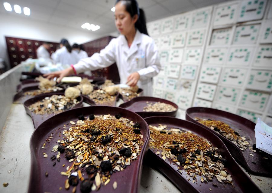 A doctor of Shanxi College of Chinese Traditional Medicine Subsidiary Hospital makes preparations of Chinese herbal medicine for patients in Taiyuan, capital of north China's Shanxi Province, Nov. 23, 2012. More and more Chinese are disposed to preventive treatment of discease rather than curative treatment, they receive acupuncture, moxibustion, herbal paste or other Chinese traditional regimen to improve sub-healthy state.(Xinhua/Yan Yan)