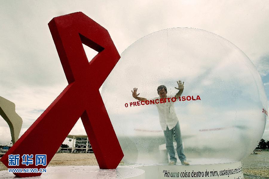 Brazilian actor Luo Muluo Augusto plays a HIV patient being isolated from society in a big plastic ball in front of the Prana Alto Palace in Brasilia, capital of Brazil. He appealed people stopping fears and prejudices against HIV/AIDS patients. (Xinhua/AFP)