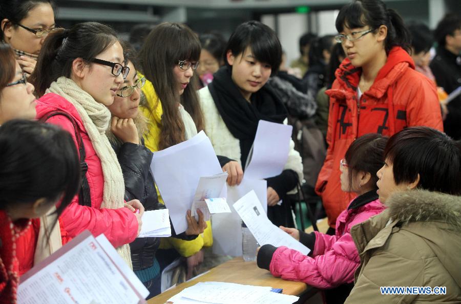 Students communicate with recruiters at a job fair in Tianjin Normal University in north China's Tianjin Municipality, Dec. 2, 2012. Tianjin Normal University held a job fair for its fresh graduates in 2013 on Sunday, which attracted over 200 enterprises. (Xinhua/Liu Dongyue)