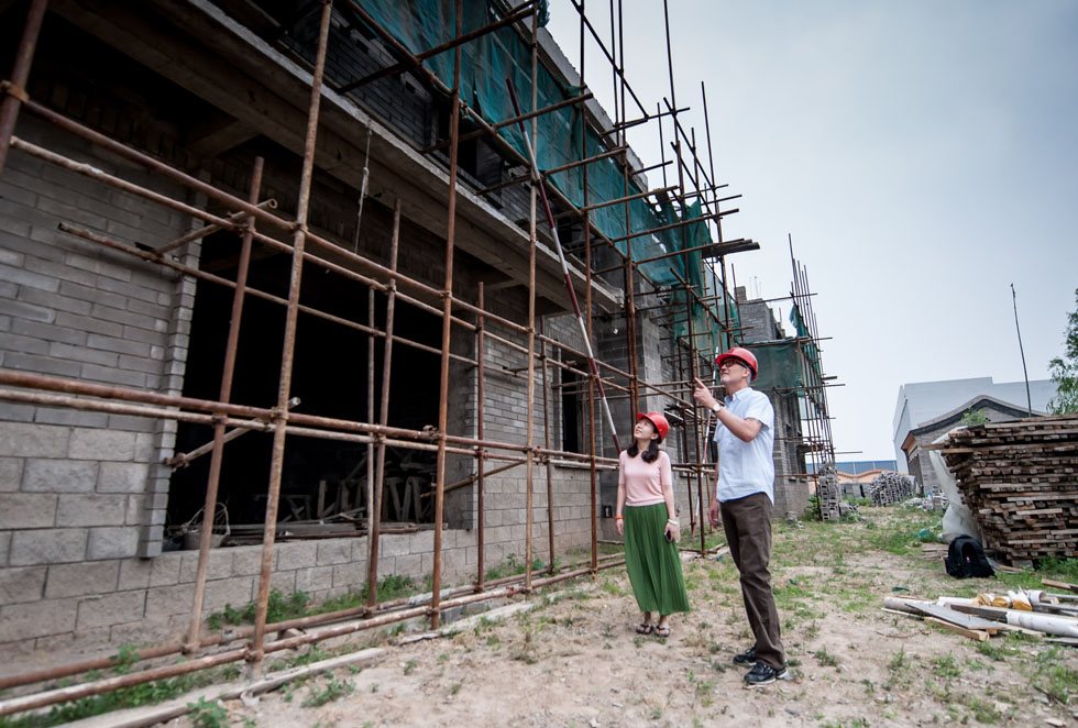 Tim Baker (R) inspects the construction work of a vocational center to be used for the children at the Shepherd's Field with one of his colleagues in Tianjin, north China, May 29, 2012.(Xinhua/Zhang Chaoqun)