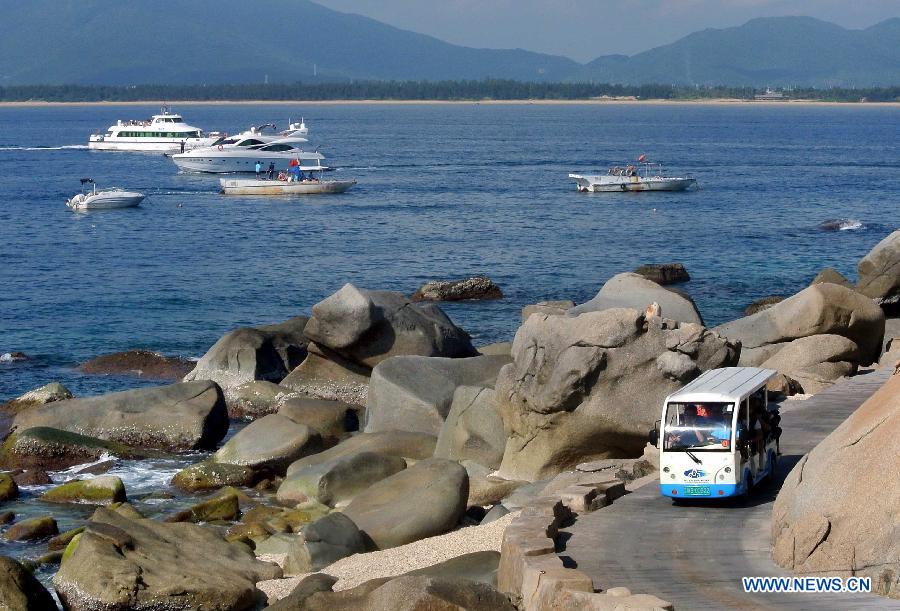 Tourists do sightseeing on Wuzhizhou Island, a scenic spot in Sanya, south China's Hainan Province, Dec. 1, 2012. Sanya has always been a winter tourism preferrence thanks to its tropical climate. (Xinhua/Wang Song) 