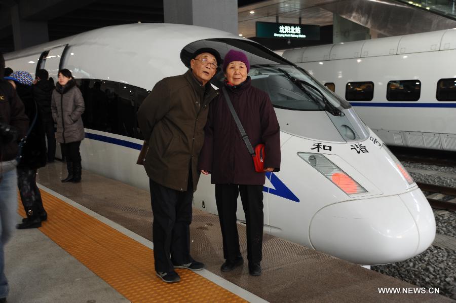 A couple pose for pictures in front of a D5008 high-speed train at the Shenyang North Railway Station in Shenyang, capital of northeast China's Liaoning Province, Dec. 1, 2012.  (Xinhua/Li Chengzhi)