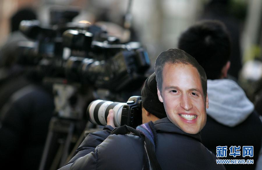 A photographer takes pictures with an image of Prince William on his head outside King Edward VII hospital, where Catherine, the Duchess of Cmabridge, hospitalizes for her sickness due to pregnancy, in central London of Britain, on Dec. 4, 2012. British royal Prince William and his wife Catherine are expecting their first child. (Xinhua/Bimal Gautam)