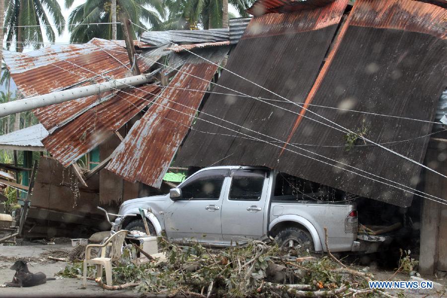Photo taken on Dec. 5, 2012 shows a damaged car and house after typhoon Bopha hit New Bataan town in southern province of Compostela Valley, the Philippines. The death toll from typhoon Bopha, locally known as Pablo, rises to 224, as Bopha continues to ravage several southern Philippine provinces. (Xinhua/JEMA)