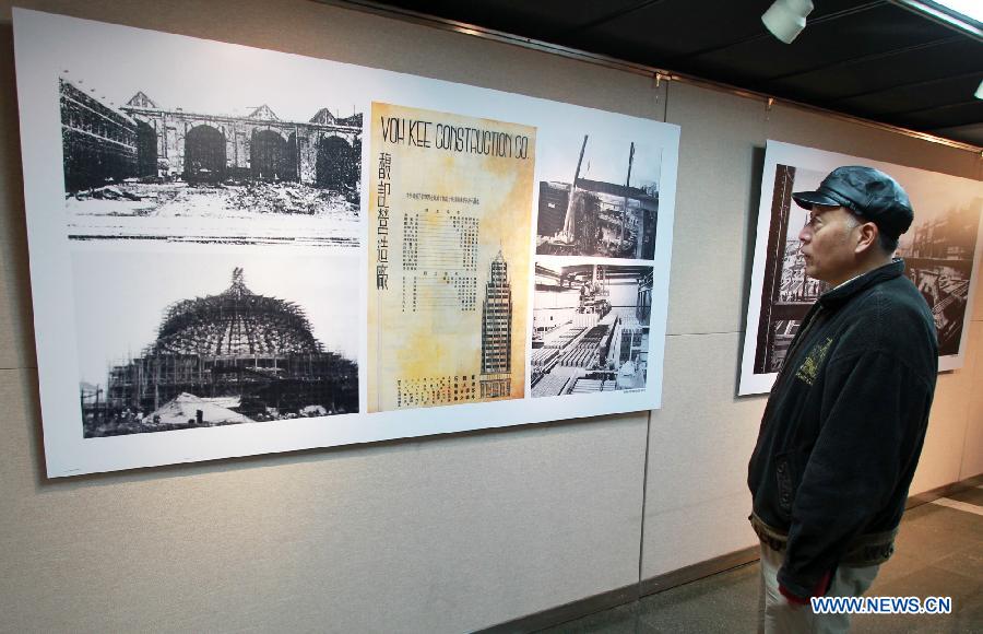 A man looks at pictures displayed at a photo exhibition on China's steel structure in the city library of east China's Shanghai Municipality, Dec. 5, 2012. The exhibition which kicked off on Wednesday will last until Dec. 9, 2012. (Xinhua/Ding Ting)