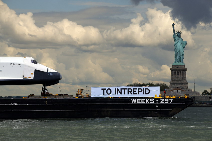 The “Enterprise” space shuttle passes the Statue of Liberty as it rides on a barge in New York harbor on June 6, 2012 (Reuters/Mike Segar)