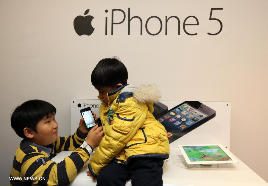 South Korean children look at the iPhone 5 during the iPhone 5 launch event in Seoul, South Korea, Dec. 7, 2012. (Xinhua/Park Jin hee) 
