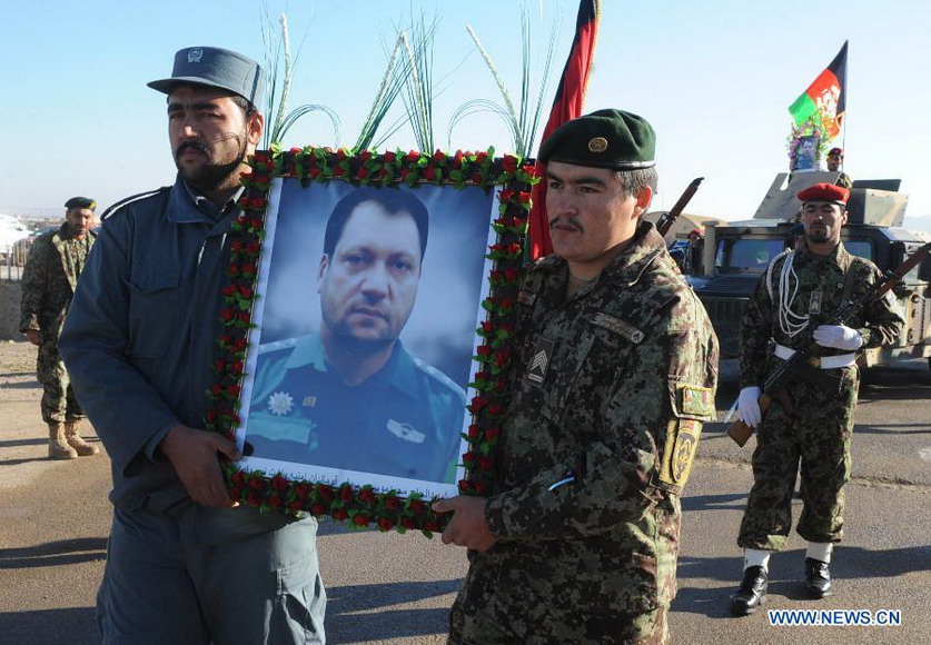 Afghan soldiers carry a portrait of Mohammad Musa Rasouli, the provincial police chief of Afghanistan's southwestern province of Nimroz, during his funeral in Herat province, west of Afghanistan, on Dec. 11, 2012. Mohammad Musa Rasouli was killed Monday in a blast in neighboring Herat province. (Xinhua/Sardar)  