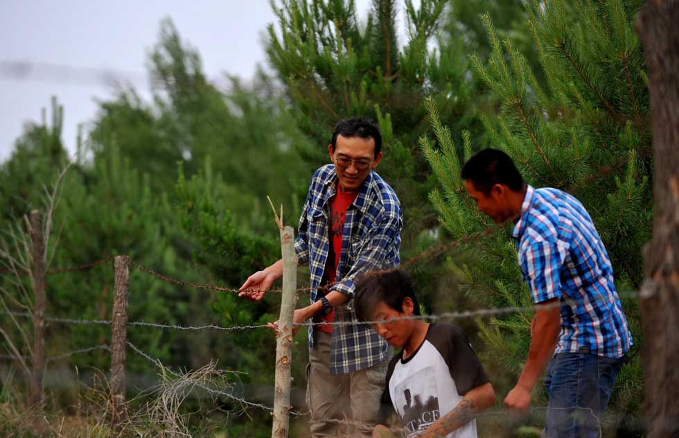 Otaki Takashi (L) works with members of Green Network in Kulun Banner of Tongliao City, north China's Inner Mongolia Autonomous Region, June 11, 2012. (Xinhua/Ren Junchuan)