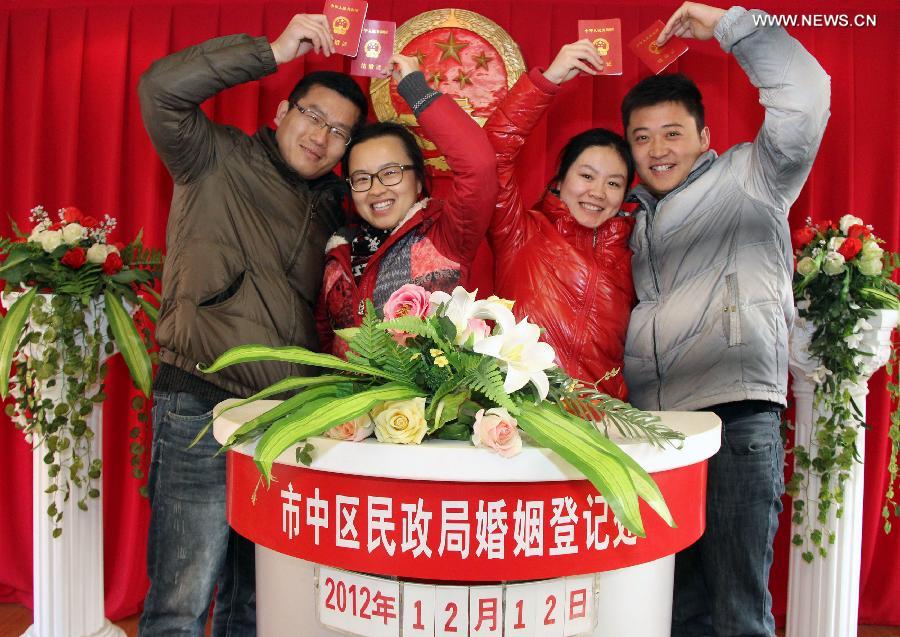 Young couples show their marriage certificates at a civil affairs bureau in Zaozhuang City, east China's Shandong Province, Dec. 12, 2012. Young couples across the country rushed to get married on Dec, 12, 2012, or 12/12/12, hoping that the "triple 12 day" will bring them good luck. In Chinese, the number 12 is pronounced like "Yao Ai", meaning "To Love" in English. (Xinhua/Sun Zhongzhe)