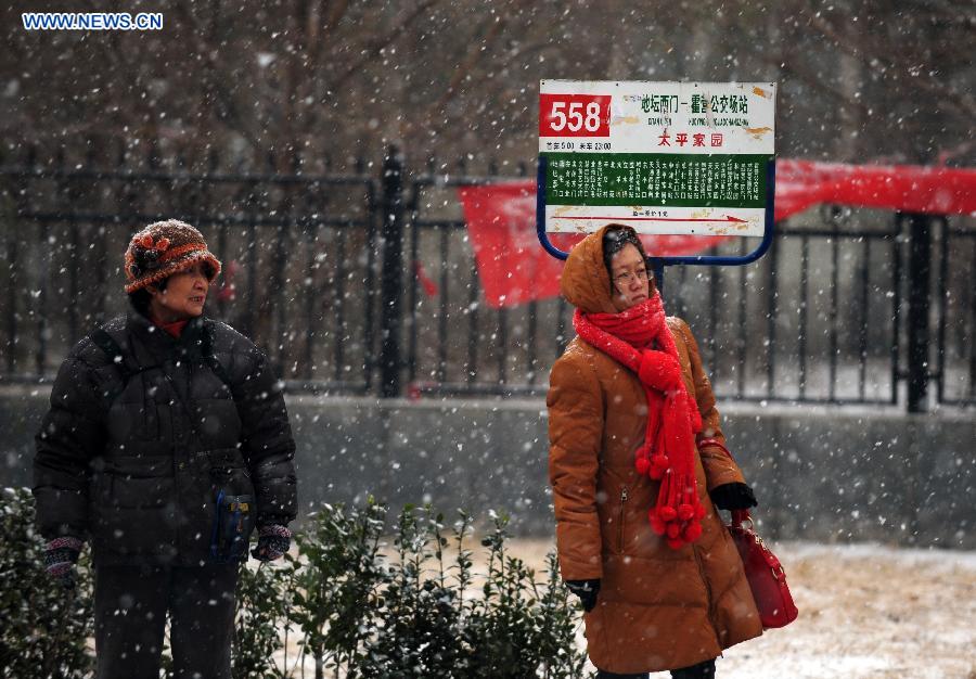 Citizens wait for buses in snow in Tiantongyuan, Beijing, capital of China, Dec. 12, 2012. A snow hit China's capital city on Wednesday. (Xinhua/Yin Bogu)