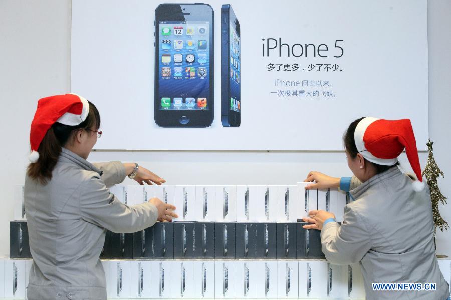 Salespersons count the number of iPhone 5 cell phones to be sold in Binhai New Area in Tianjin, north China, Dec. 13, 2012. Apple iPhone 5 is scheduled to be released in the Chinese mainland on Friday. (Xinhua)
