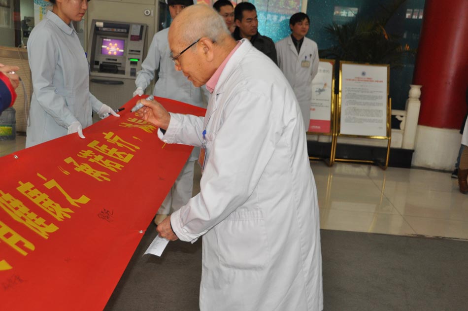 A senior medical staff of Beijing Ruijing Diabetes Hospital writes down his name on the banner on Dec. 12, 2012, as a way of making a commitment to provide better medical service. The campaign for providing patient-oriented medical service has been officially launched in the hospital on Wednesday afternoon.  (Photo/People's Daily Online)