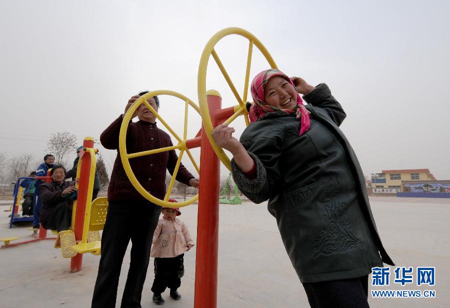 Villagers from Yang Wayao village do exercises on the playground in Lanzhou, Gansu province. (Xinhua Photo)