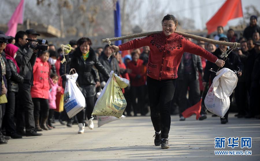 A woman competes in a competition of carrying a load in Peasant Games held in Ningxia. (Xinhua Photo)