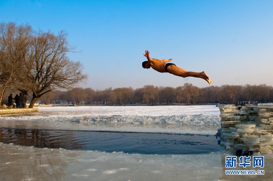 Photo taken on Jan.6, 2012 shows a man jumping into water of winter outdoor swimming area in Beiling Park in Shenyang, N China. (Xinhua Photo)