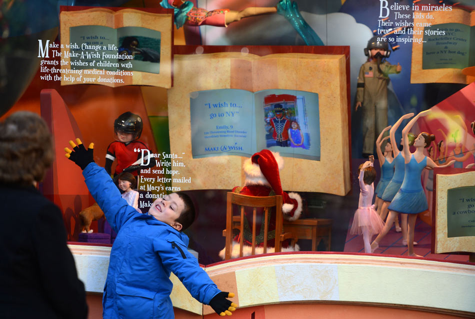 A child has a picture taken in front of the Christmas window of Macy's in Manhattan, New York, U.S. , Dec. 13, 2012.(Xinhua/Wang Lei)