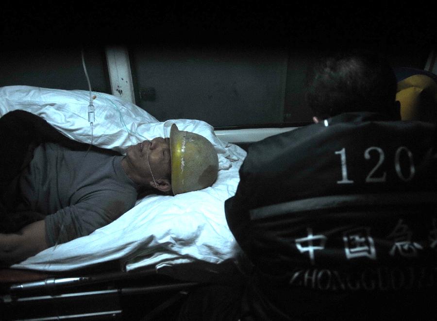 A trapped worker receives treatment at a railway tunnel in Lanzhou, capital of northwest China's Gansu Province, Dec. 14, 2012. Five construction workers who were buried in a tunnel that was under construction around 2:50 p.m. on Wednesday were rescued at 10:07 p.m. Friday. (Xinhua/Nie Jianjiang) 