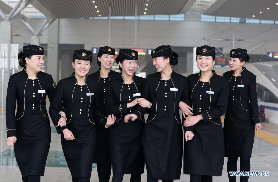 Stewardesses walk out of the railway station in Zhengzhou, capital of Henan Province, Dec. 14, 2012. China is set to open the world's longest high-speed railway on Dec. 26, linking the country's capital city of Beijing and the southern economic center of Guangzhou. (Xinhua/Zhu Qing)