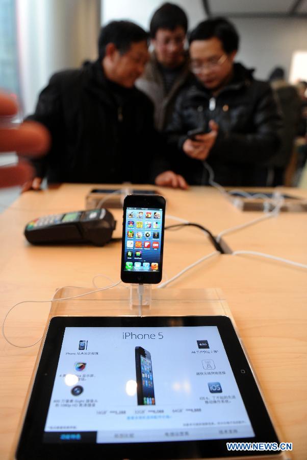 Customers experience Apple's iPhone 5 at a Apple retail store in Beijing, capital of China, on Dec. 14, 2012. Apple iPhone 5 was released in the Chinese mainland on Friday. (Xinhua/Luo Xiaoguang)