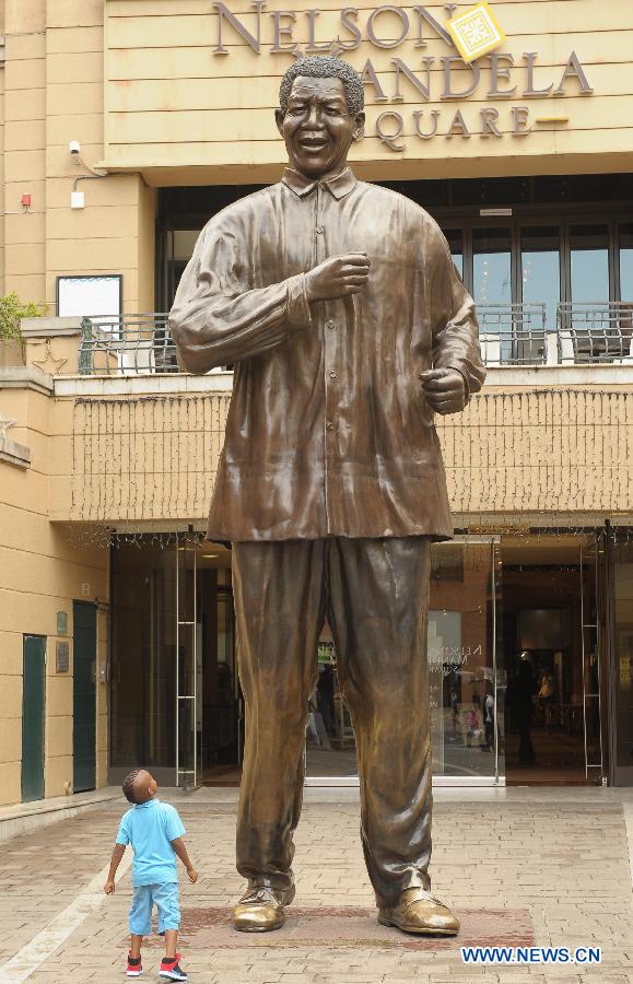 A child looks up a statue of former South African president Nelson Mandela on Nelson Mandela Square in Johannesburg, South Africa, on Dec. 18, 2012. South African President Jacob Zuma said on Tuesday that doctors are satisfied with the progress former president Nelson Mandela is making during his treatment. (Xinhua/Li Qihua) 