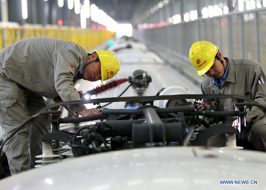 Technicians checks the pantograph of a bullet train in Shanghai Municipality, Dec. 19, 2012. Shanghai Railway Bureau conducted a comprehensive overhaul of all the bullet trains to ensure the demand of vehicles during the coming spring rush on Wednesday. (Xinhua/Chen Fei) 