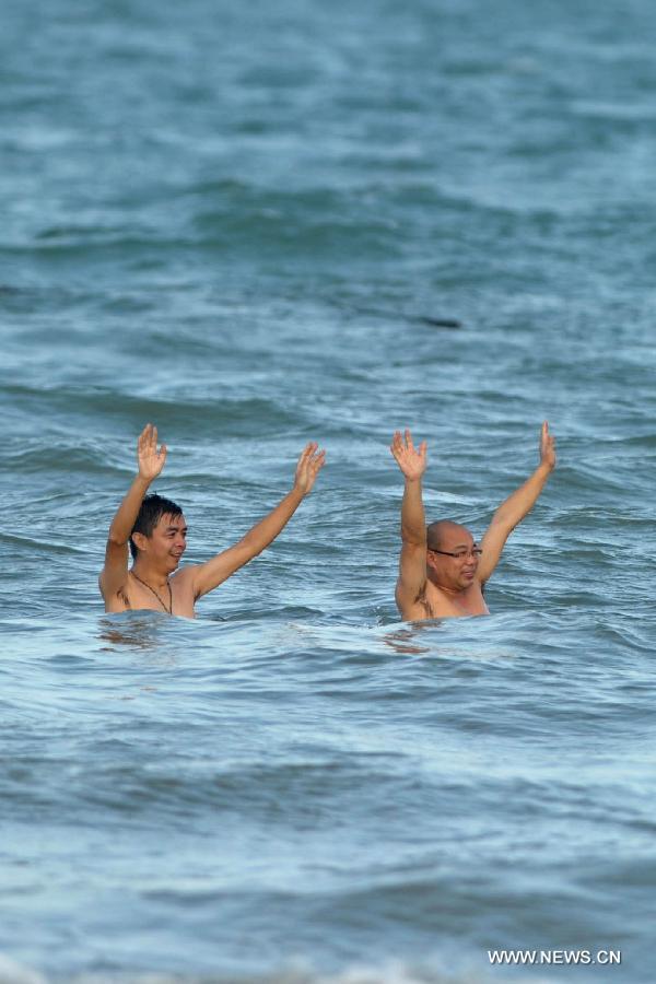 People swim in the sea in Haikou, capital of south China's Hainan Province, Dec. 21, 2012. Thursday marks the Dongzhi Festival, or Winter Solstice. Contrary to people in north China who are expected to welcome the coldest winter days, people in Hainan still enjoy the warm climate. (Xinhua/Zhao Yingquan)
