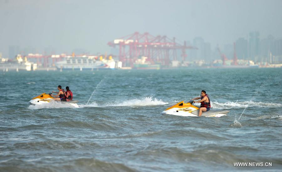 People play motorboats on the sea in Haikou, capital of south China's Hainan Province, Dec. 21, 2012. Thursday marks the Dongzhi Festival, or Winter Solstice. Contrary to people in north China who are expected to welcome the coldest winter days, people in Hainan still enjoy the warm climate. (Xinhua/Zhao Yingquan) 