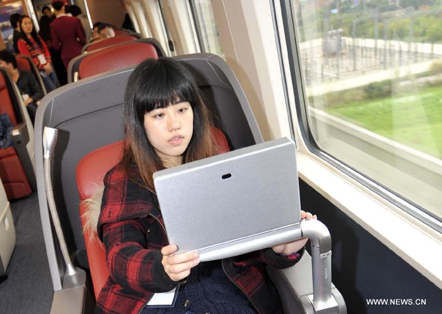A passenger watches television in a business class carriage of G80 express train during a trip to Beijing, capital of China, Dec. 22, 2012. (Xinhua/Chen Yehua) 