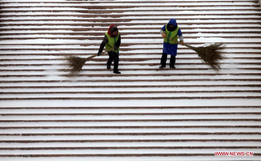 Sanitation workers clean the snow on the stairs in Xingfu Park in Weihai, east China's Shandong Province, Dec. 23, 2012. A severe cold wave is sweeping most parts of China, with temperatures dropping by around 10 degrees Celsius in some areas. The local meteorological authority issued a blue alert for the cold wave. (Xinhua/Yu Qibo) 