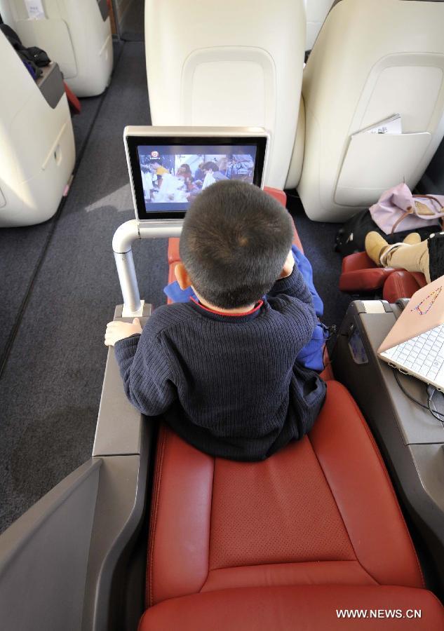 A child watches television in a business class carriage of G80 express train during a trip to Beijing, capital of China, Dec. 22, 2012.