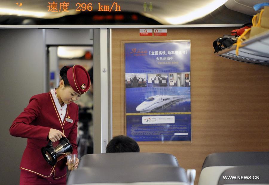 A stewardess provides service on G80 express train during a trip to Beijing, capital of China, Dec. 22, 2012.