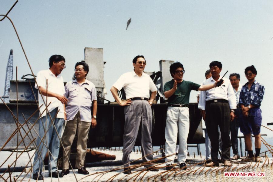 File photo taken in 1994 shows Yu Zhengsheng (3rd L) inspects the construction of a cross-sea highway in Qingdao, a coastal city in east China's Shandong Province. (Xinhua) 