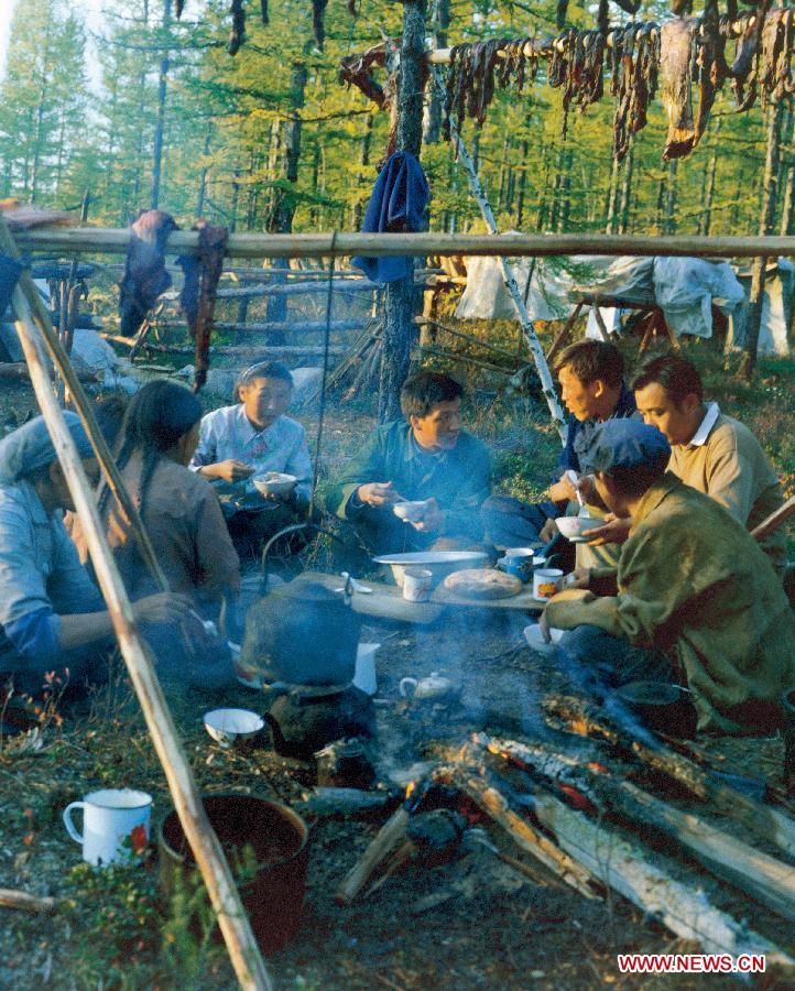 In this file photo taken in the autumn of 1981, Liu Yunshan (C), then a Xinhua reporter, talks with Ewenqi hunters during an interview in Olguya, north China's Inner Mongolia Autonomous Region. (Photo/Xinhua) 