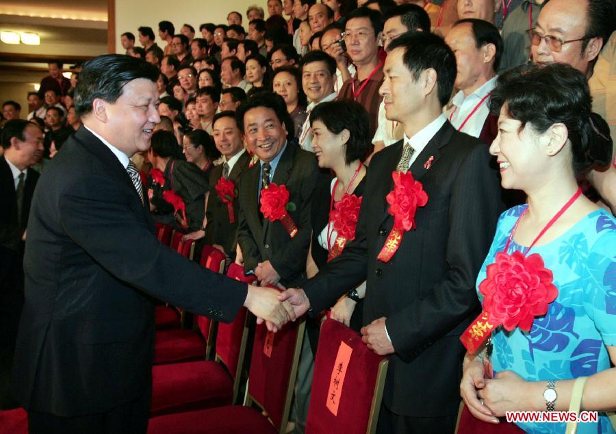 In this file photo taken on July 19, 2004, Liu Yunshan (L, front) meets representatives attending a commendation ceremony of young and middle-aged Chinese literary and art workers with supreme virtue and artistic achievements at the Great Hall of the People in Beijing, capital of China. (Xinhua/Li Xueren)
