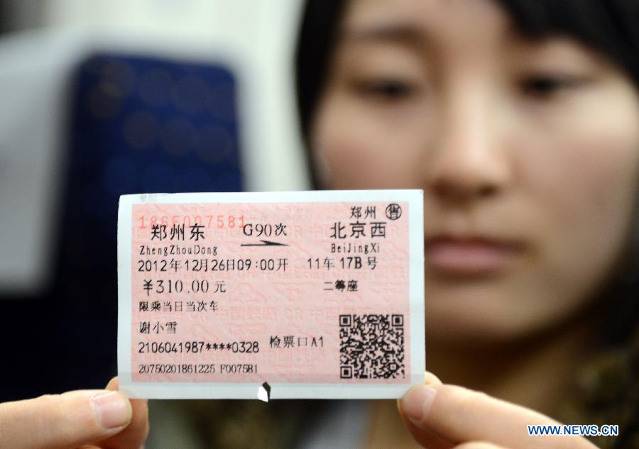 Passenger Xie Xiaoxue shows her ticket of high-speed train G90, which is to leave for Beijing, capital of China, from the Zhengzhou East Railway Station in Zhengzhou, capital of central China's Henan Province, Dec. 26, 2012.  (Xinhua/Zhao Peng)