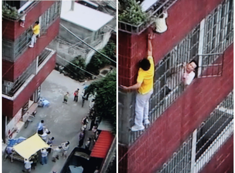Zhou Cong, stepping on the windows of the third floor, lifts a little girl falling from the 4th floor in a residential building in Guangzhou on June 3, 2012. 