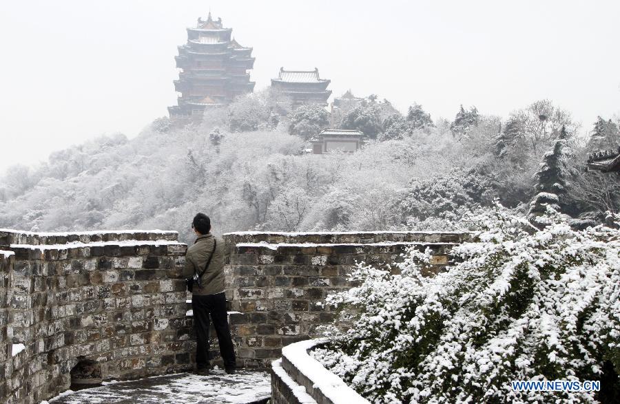 A citizen takes photos of a snow-covered scenic spot in Nanjing, capital of east China's Jiangsu Province, Dec. 26, 2012. Many parts of Jiangsu saw a snowfall on Wednesday. (Xinhua/Dong Jinlin)
