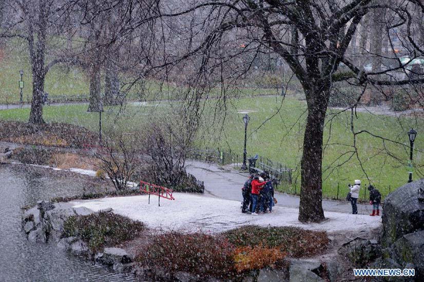 People walk in a winter storm as snow falls at the Central Park in New York City on Dec. 26, 2012. The strong storm system that hit the central and southern U.S. on Christmas Day moved to the eastern U.S. on Wednesday, causing flight delays and dangerous road conditions in the Northeast. (Xinhua/Wang Lei) 