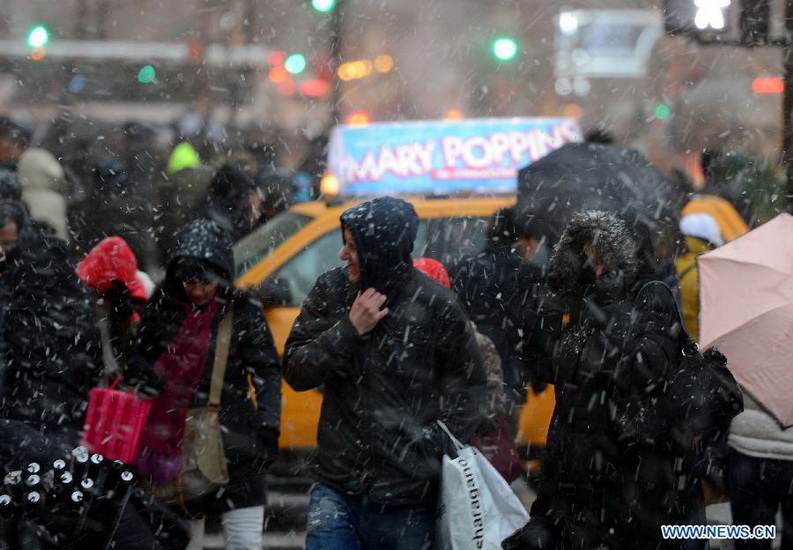 People walk in a winter storm as snow falls in Manhattan, New York City, on Dec. 26, 2012. The strong storm system that hit the central and southern U.S. on Christmas Day moved to the eastern U.S. on Wednesday, causing flight delays and dangerous road conditions in the Northeast. (Xinhua/Wang Lei) 