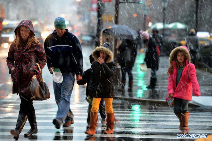 People walk in a winter storm as snow falls in Manhattan, New York City, on Dec. 26, 2012. The strong storm system that hit the central and southern U.S. on Christmas Day moved to the eastern U.S. on Wednesday, causing flight delays and dangerous road conditions in the Northeast. (Xinhua/Wang Lei) 