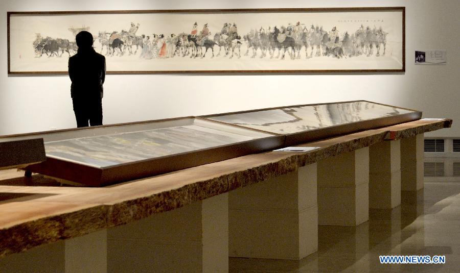 A visitor views an exhibit in the Chinese long painting exhibition at Zhejiang Art Museum in Hangzhou, capital of east China's Zhejiang Province, Dec. 26, 2012. (Xinhua/Shi Jianxue)
