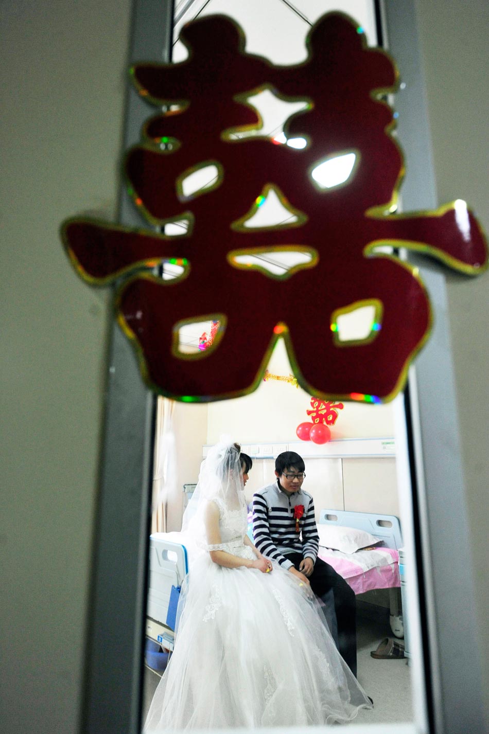A special wedding ceremony is held in a ward of Qianfoshan Hospital, Shandong province, Feb. 14, 2012. Although the bridegroom suffered from uremia, the bride still chose to stand by him and fight against the disease together. (Xinhua/Cui Jian)