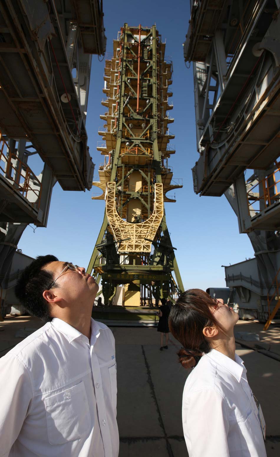 On June 11, Jia Lide (R) and Li Ting (L) stand under the launching tower of Dongfanghong-I in Jiuquan Satellite Launch Center, Northwest China’s Gansu province. The couple has been committed to China’s aerospace industry since obtaining doctoral degree in National University of Defense Technology. (Xinhua/Wang Jianmin)