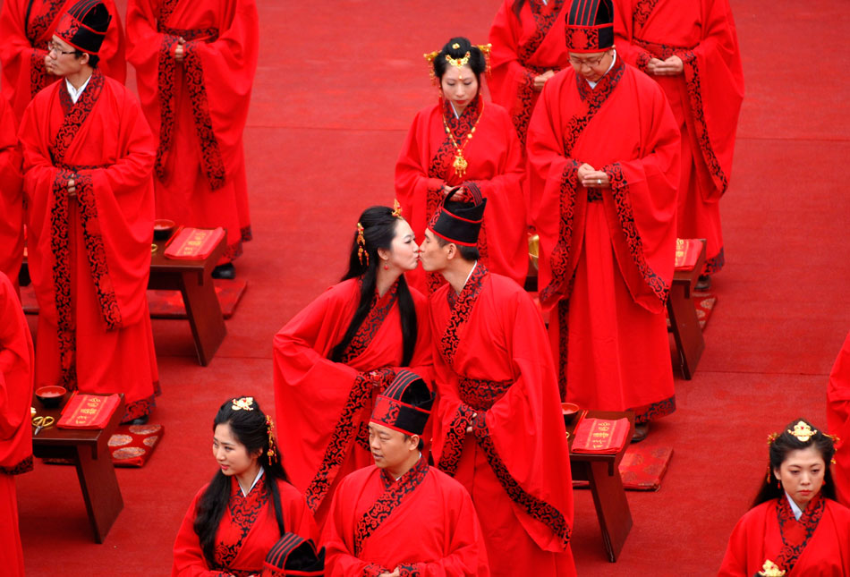 A pair of newly-wed couple kisses each other in a group wedding ceremony which follows etiquettes of Han Dynasty, in Xi’an, capital of northwest China's Shaanxi province, May 1, 2012. 