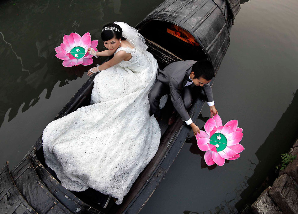 A newly-wed couple floats river lanterns in Shaoxing, Zhejiang province, May 27, 2012. Floating river lanterns is a traditional custom for people to make a wish in holidays. (Xinhua/Wang Song)
